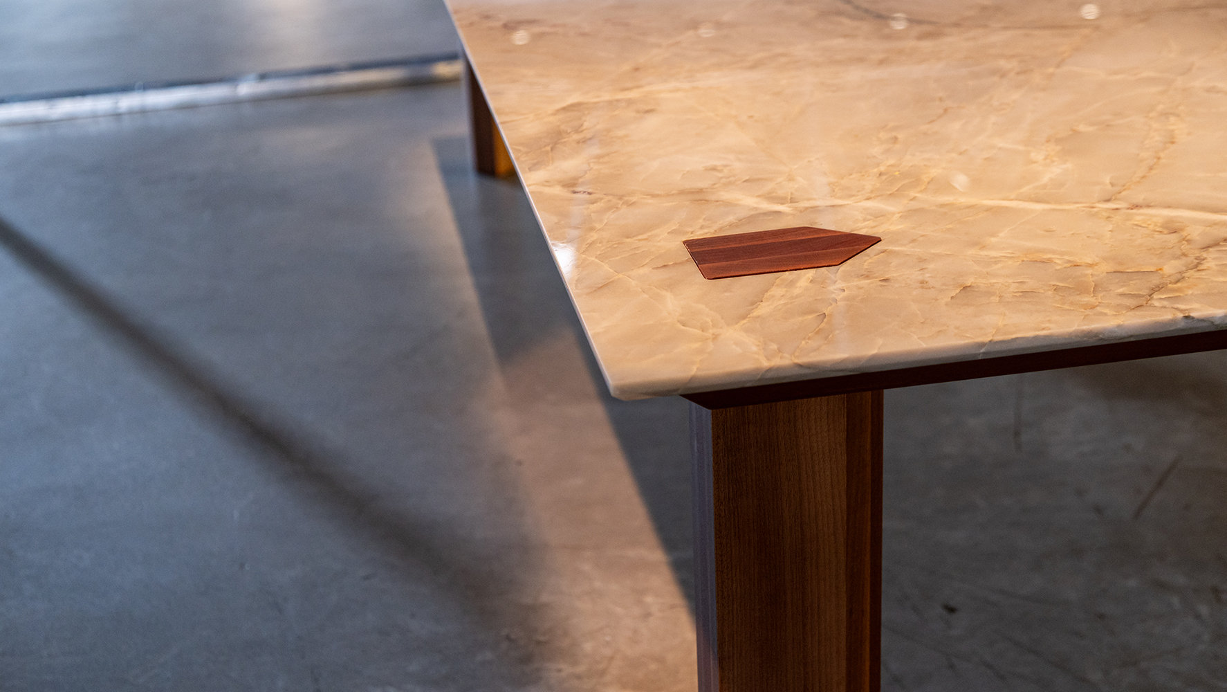 Detalhe da mesa de jantar Celeiro, desenhada pelo Estúdio Mula Preta, com encaixe lúdico entre madeira e pedra | Foto: Monique Araújo/ DW!